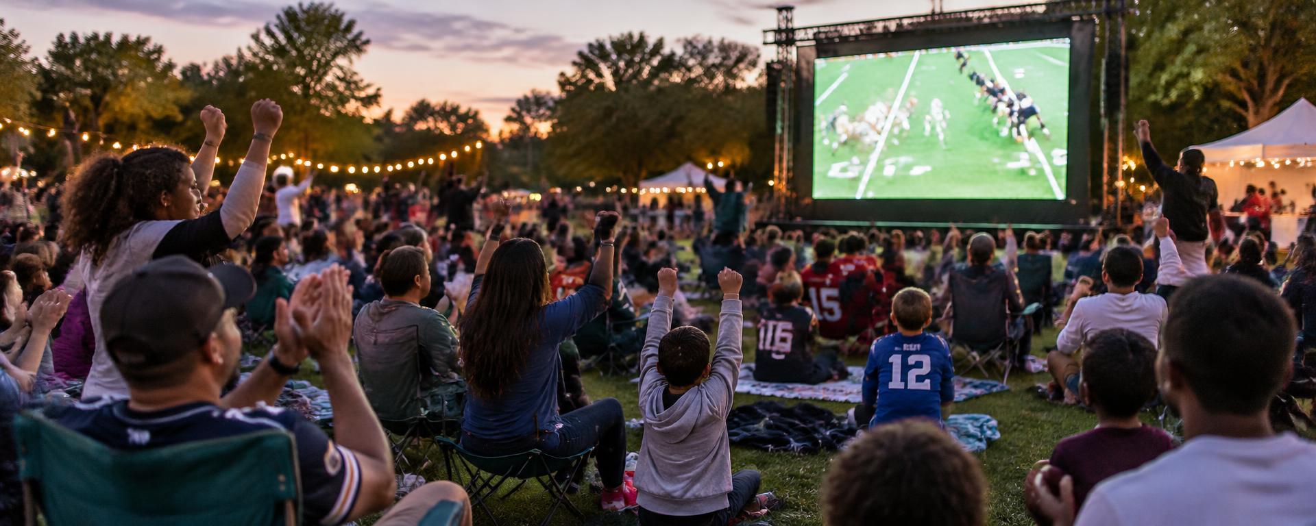 Community sports watch party in front of an outdoor LED video wall